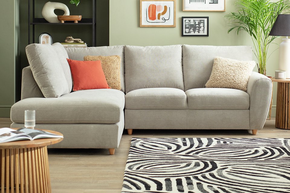 Grey sofa in living room with accessories and plants.